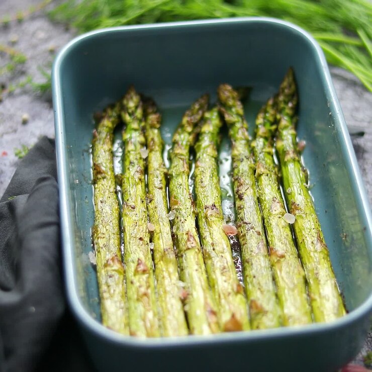 Roasted asparagus seasoned with salt pepper garlic and decorated with fresh herbs