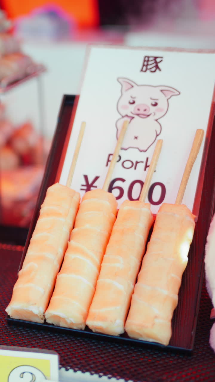 Close up of pork and beef skewers at a street food market in Japan. Vertical