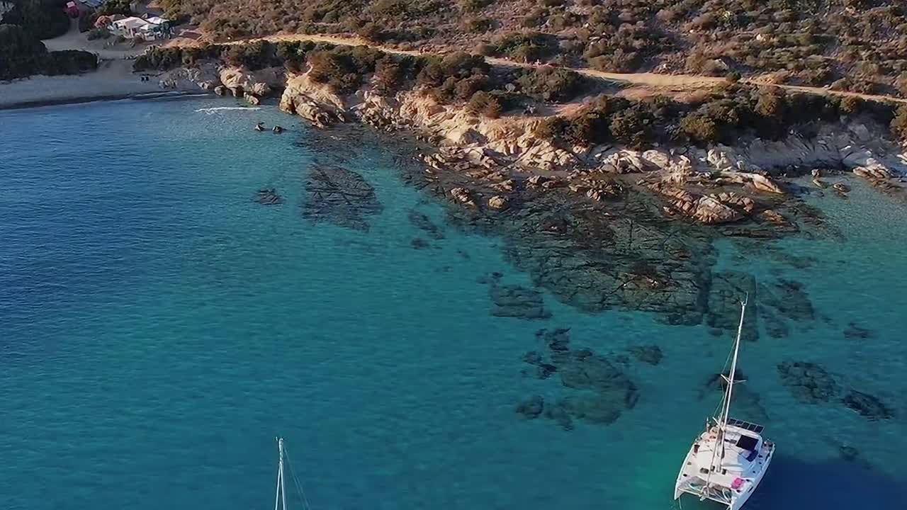 Esplorando le coste della Sardegna con barche vicino all'acqua cristallina