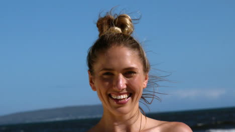 Smiling-blonde-holding-up-starfish-on-the-beach