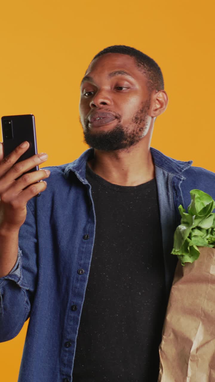Happy Man Talking on Smartphone While Holding Groceries