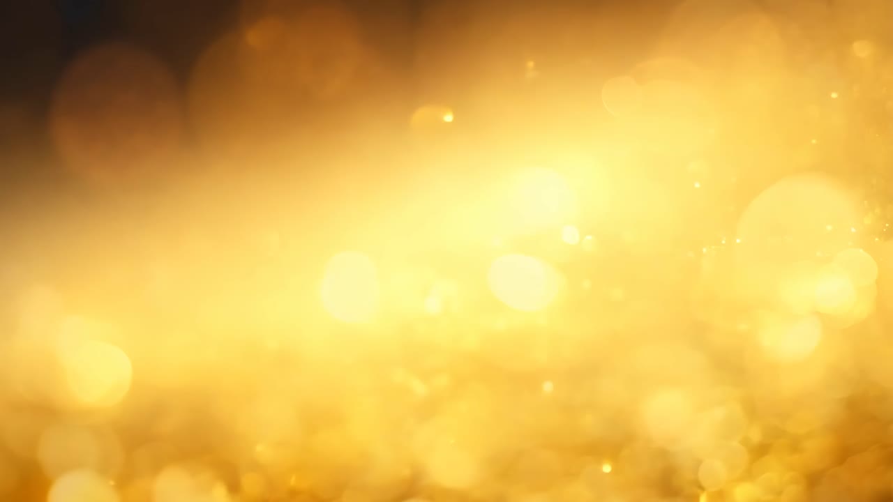 A gold glittery background with a few small gold specks. The background is very shiny and the gold specks are scattered throughout the image