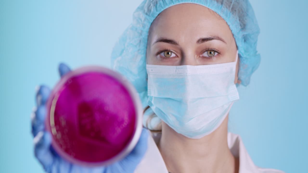 Scienziato che tiene una capsula di Petri con coltura batterica