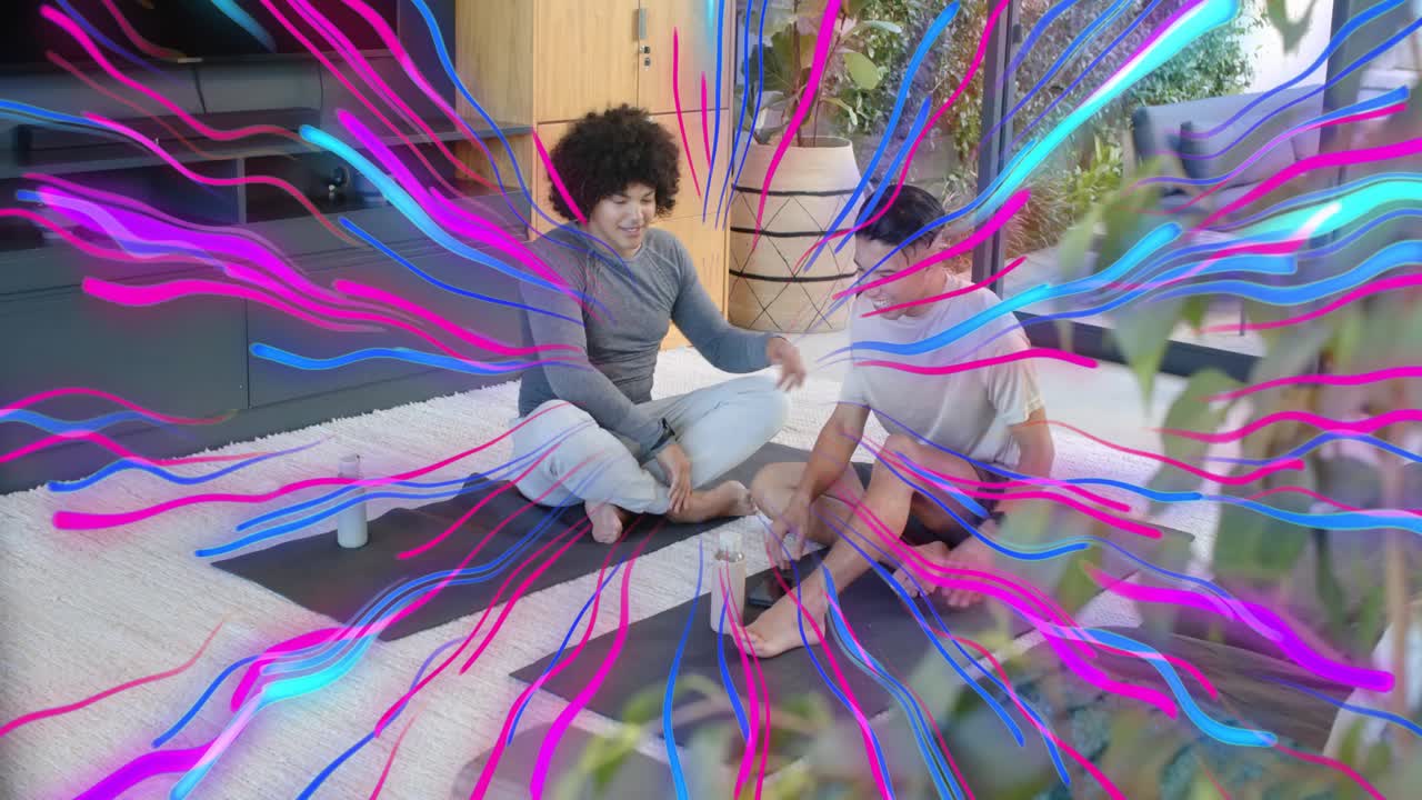 Two men sitting on yoga mats tapping phone creating animated streaks while sharing fitness stats