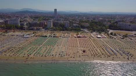 idyllic seascape with a lot of parasols and sunbeds in rimini, italy - aerial sideways