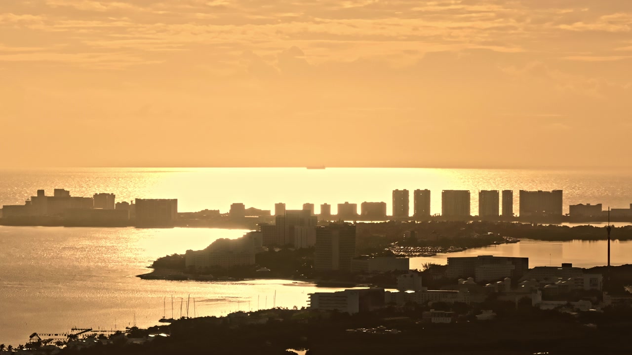 Vista aérea na hora dourada sobre a Lagoa Nichupté e o horizonte de Cancún, Quintana Roo, México, com a luz quente refletindo na água tropical calma.