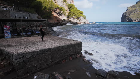 Chica-Mira-Las-Olas-En-El-Puerto-De-Sa-Calobra,-Mallorca