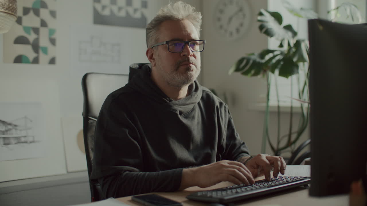 Mid-Aged Architect Working on Desktop Computer in Modern Office