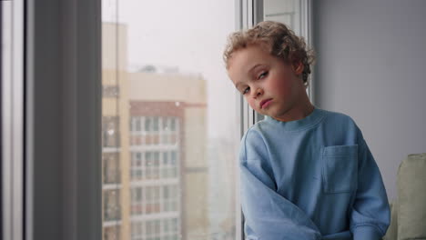 Un-Niño-Pensativo-De-Cuatro-Años-Está-Viendo-Caer-La-Nieve-Desde-La-Ventana-De-Su-Habitación-En-Un-Acogedor-Apartamento-Moderno