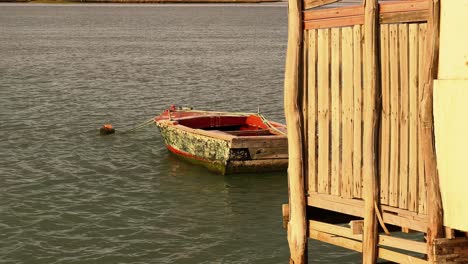 Captivating-still-footage-of-a-waterfront-scene-as-the-camera-captures-the-gradual-submersion-of-a-wooden-house-foundation-into-the-tranquil-waters-below