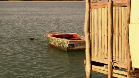 capturando imágenes fijas de una escena frente al mar mientras la cámara captura la inmersión gradual de los cimientos de una casa de madera en las aguas tranquilas de abajo
