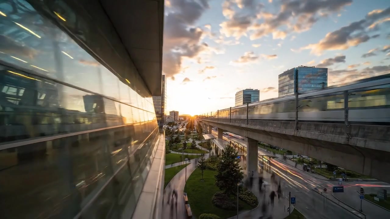 Um Pôr do Sol Urbano Deslumbrante Sobre uma Paisagem Urbana Moderna, Apresentando Edifícios de Vidro, Espaços Verdes Exuberantes e uma Linha de Transporte Proeminente Contra um Céu Dramático.
