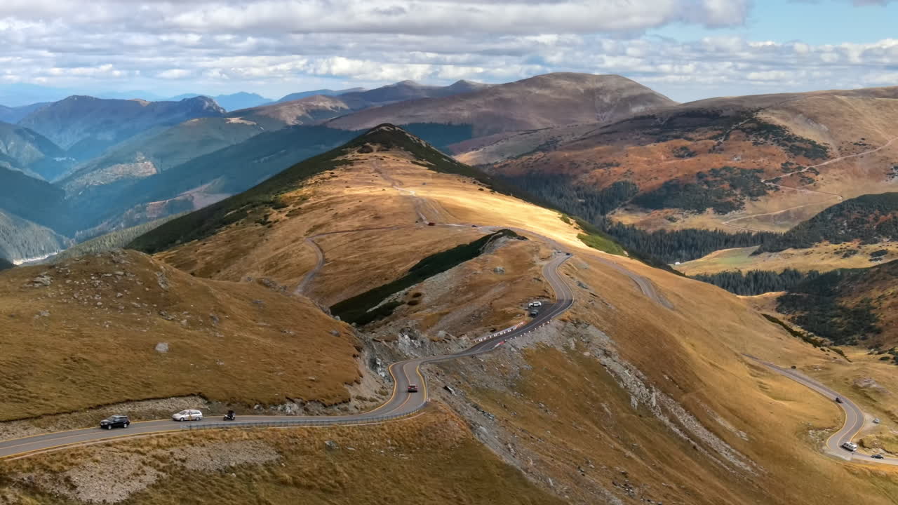 Aerial drone view of nature in Romania. Carpathian mountains, sparse vegetation, Transalpina road with cars