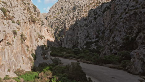 tourists trekking on dry riverbed of torrent de pareis in mallorca, spain during summer