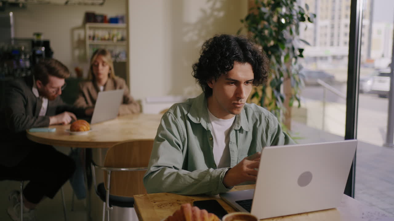 hombre trabajando en una computadora portátil en una cafetería