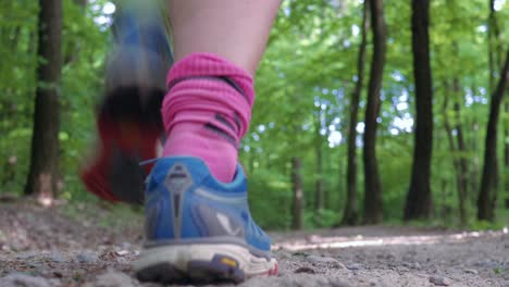 low angle shot of a trail runner in the forest jumps over the camera and moving away