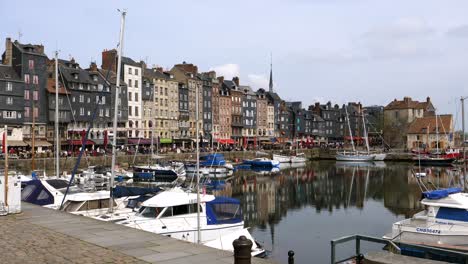 Panning-shot-of-marina-port-of-Honfleur-City-in-France-during-cloudy-day---Wide-shot