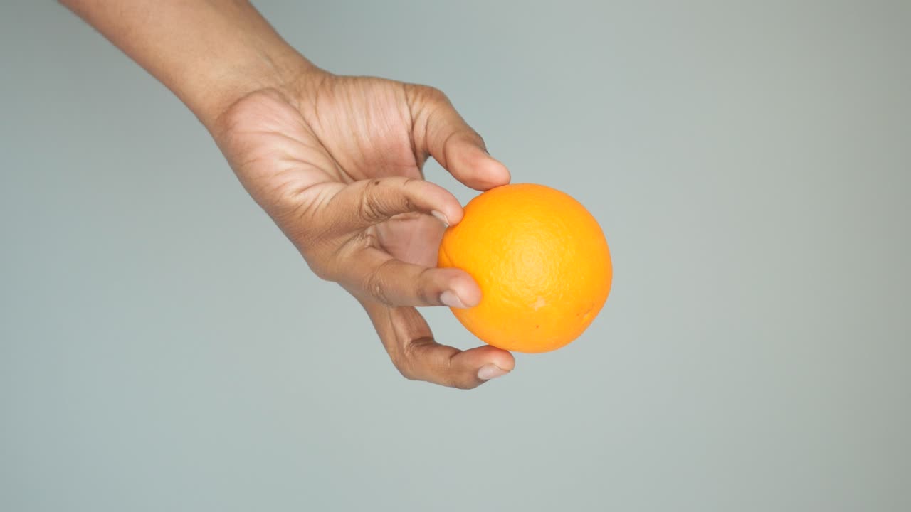 mano con una naranja