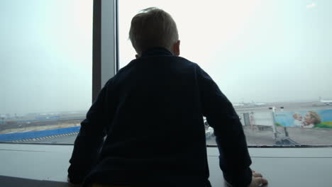 Niño-Mirando-El-Avión-Desde-La-Ventana-E-Imitándolo