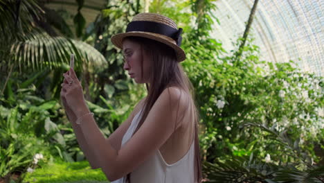 woman taking photo in a greenhouse