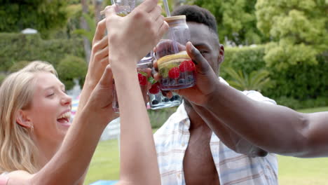 diverse friends toast drinks outdoors