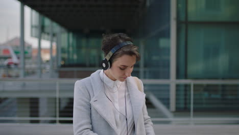 portrait of beautiful young business woman executive using smartphone removes headphones smiling happy enjoying relaxed urban lifestyle