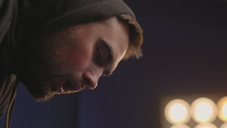 close up of a sweaty sportive man in hoodie having shortness of breath after workout