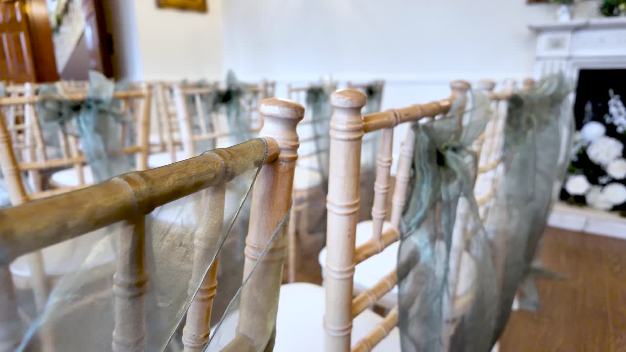 Luogo per cerimonia nuziale con file di sedie in legno decorate con nastri blu. Dettaglio della disposizione dei posti a sedere per eventi speciali e celebrazioni