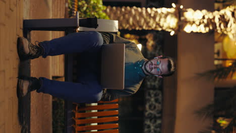 man working on laptop outdoors at night