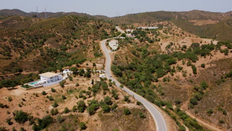 Aerial-follow-shot-of-truck-driving-on-rural-mountain-road-during-hot-summer-day---Dried-mountain-landscape-in-Portugal-during-sunlight