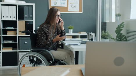 woman in wheelchair working in modern office