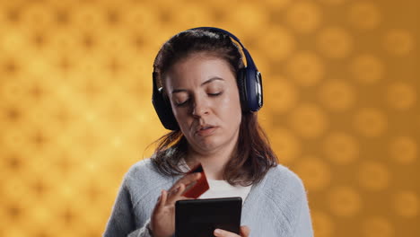 person with tablet in hands buying digital novel with credit card, hearing songs