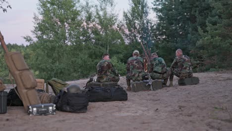 hunters in camouflage clothing after hunting for game light a bonfire, fry sausages, tell each other a story, view from behind, hidden weapons, rest