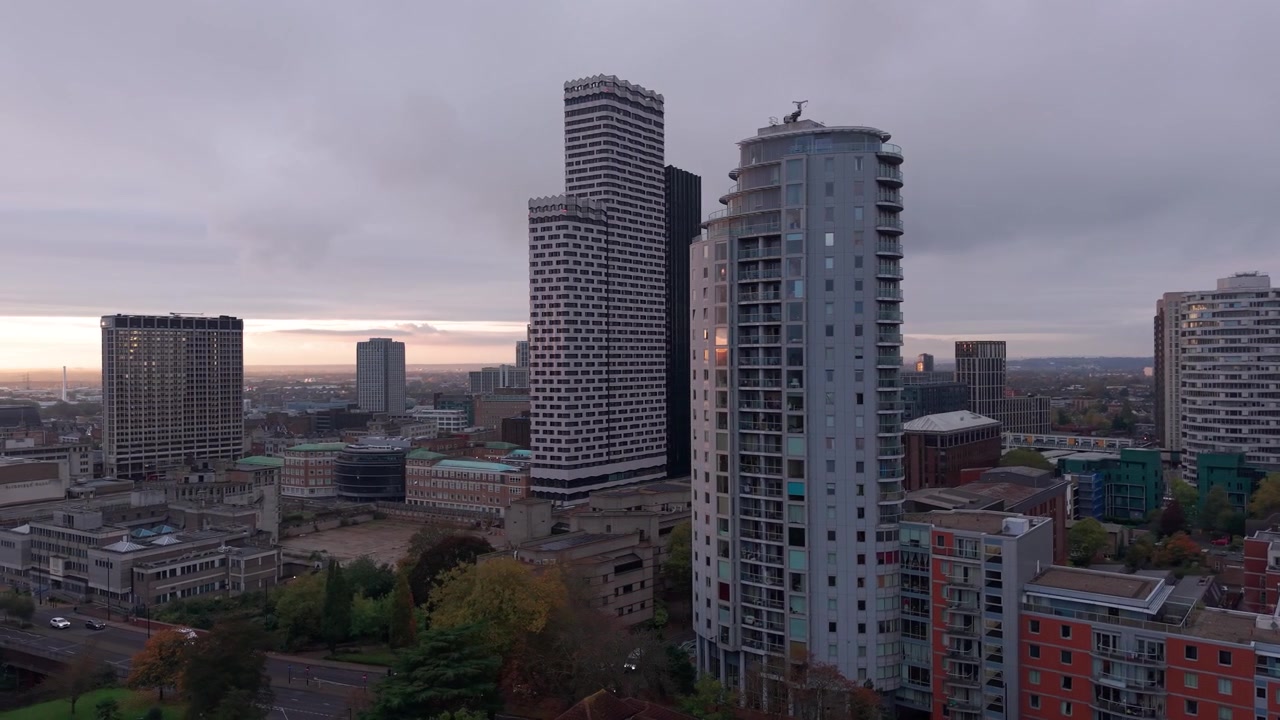 Vista aérea rodeando los rascacielos del paisaje urbano de Croydon, Londres, durante un atardecer nublado