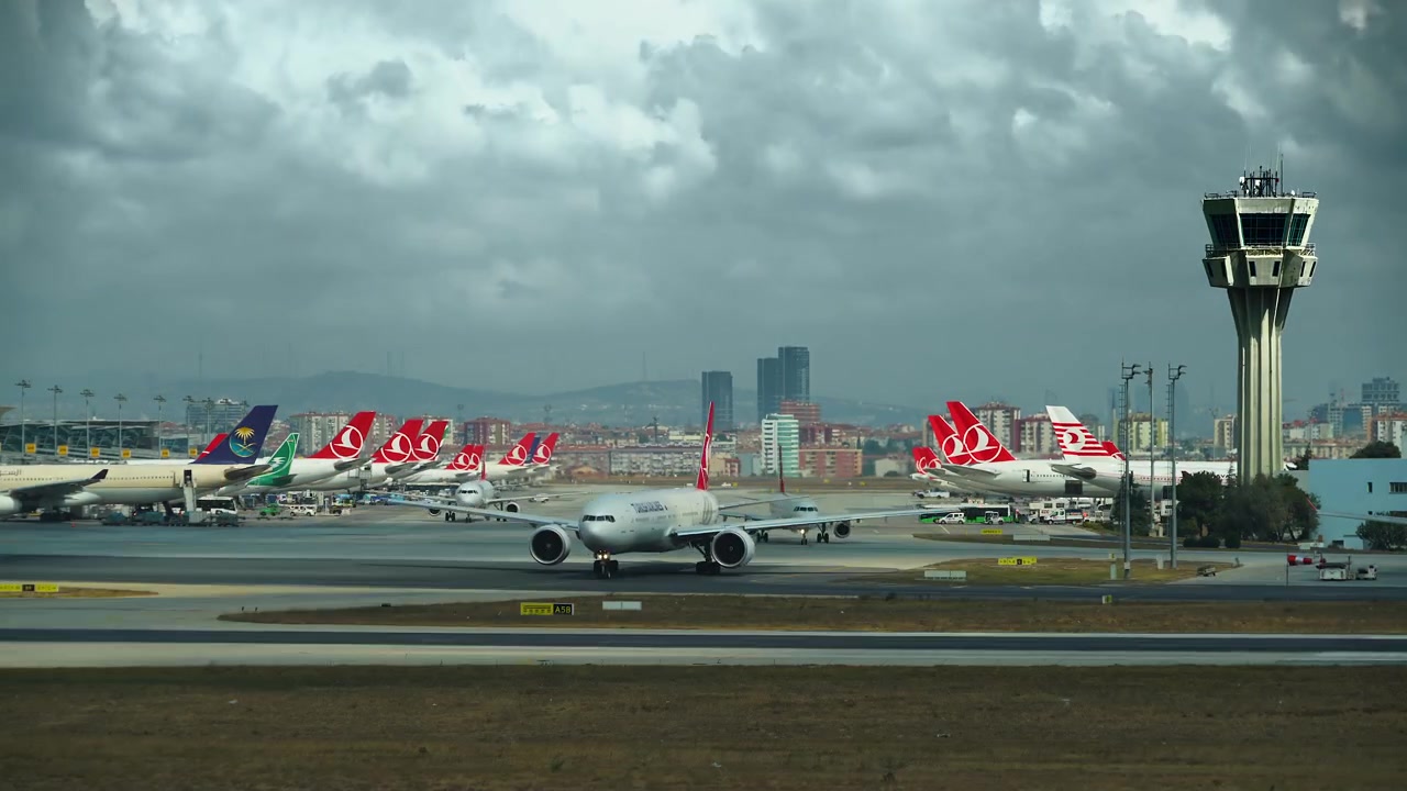 Plataforma de aeropuerto concurrida con múltiples aviones y torre de control