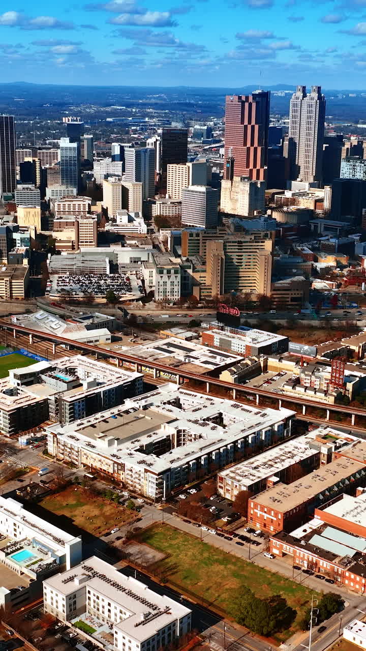 Breath-taking view of Atlanta panorama from aerial perspective. Light blue sky with many white clouds above. Top view. Vertical video