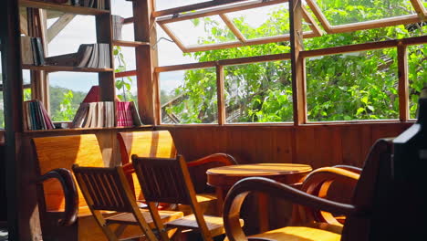 vintage wooden interior furniture with chair, table, and window overlooking lush greenery outside