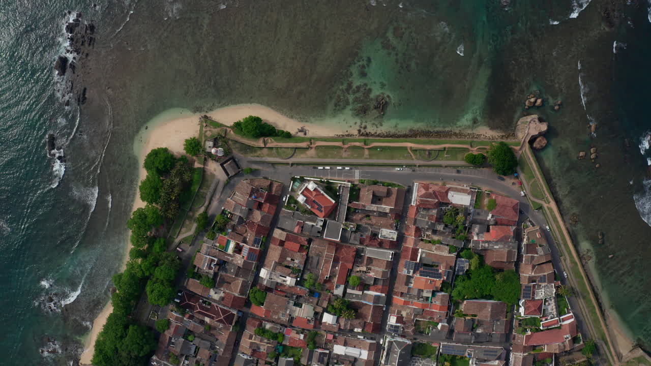 Drone hovering above Galle Fort, showing fort walls, rooftops, coastline, and beach