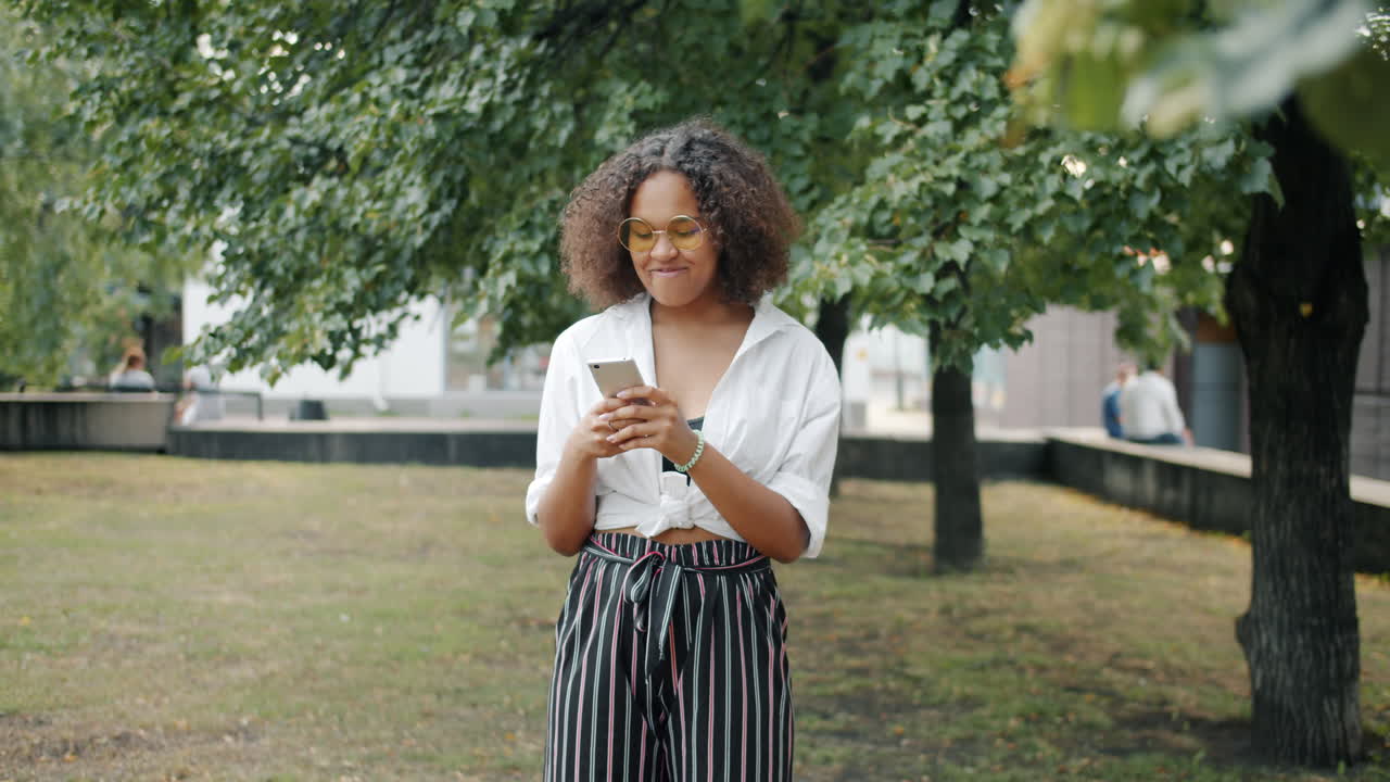 Young Woman Using Phone in Park