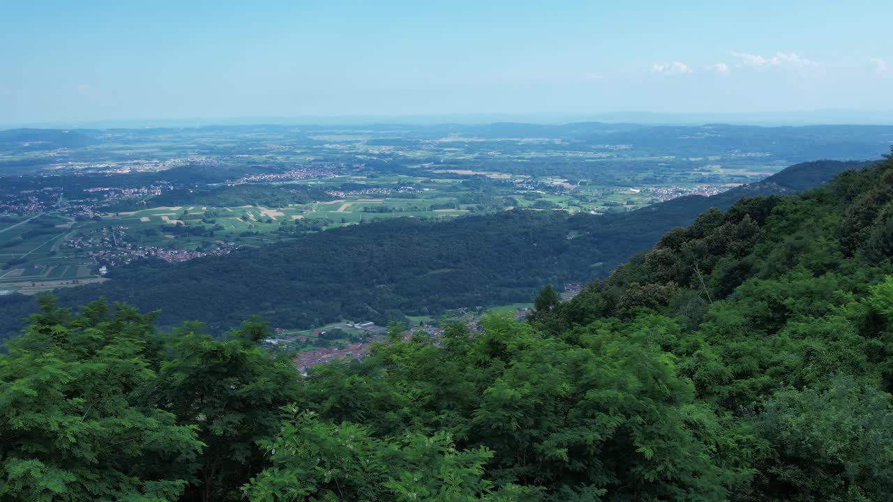 Aerial view of the Ivrea Morainic Amphitheatre, a vast glacial formation from the Pleistocene, with forests, farmland and villages near Ivrea, Italy, drone shot, slow motion