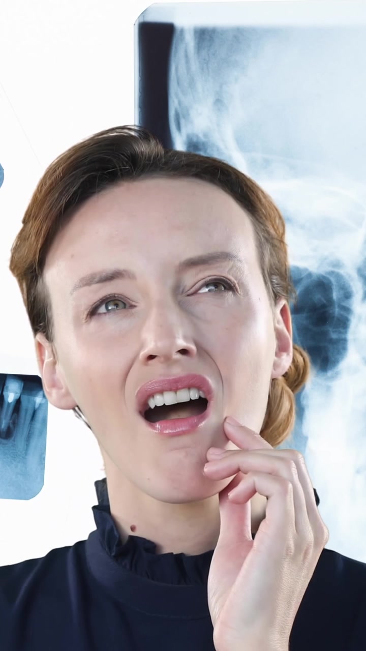 Caucasian woman touching her cheek and suffering of toothache with x ray pictures in the background