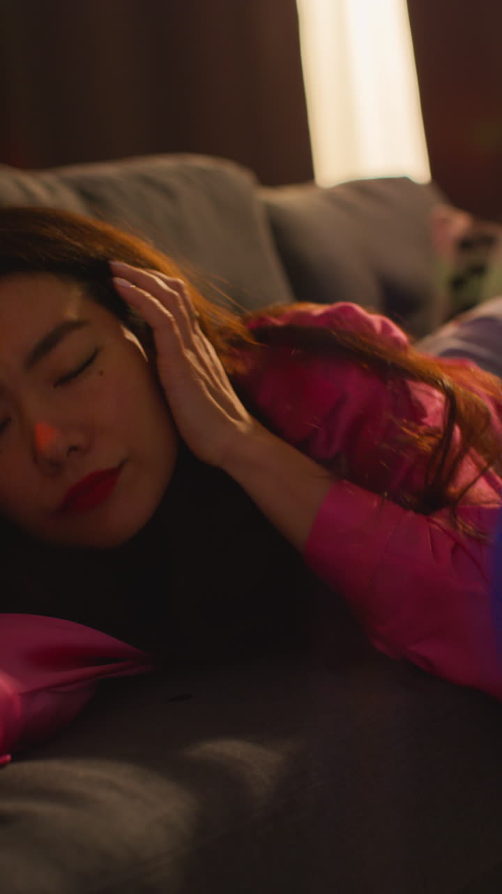 video vertical de una mujer acostada en el sofá y durmiendo después de beber alcohol en una fiesta de casa sufriendo de resaca 1