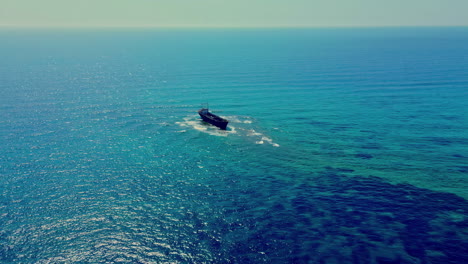 Aerial-drone-dolly-shot-of-a-cargo-ship-in-the-middle-of-the-mediterranean-sea