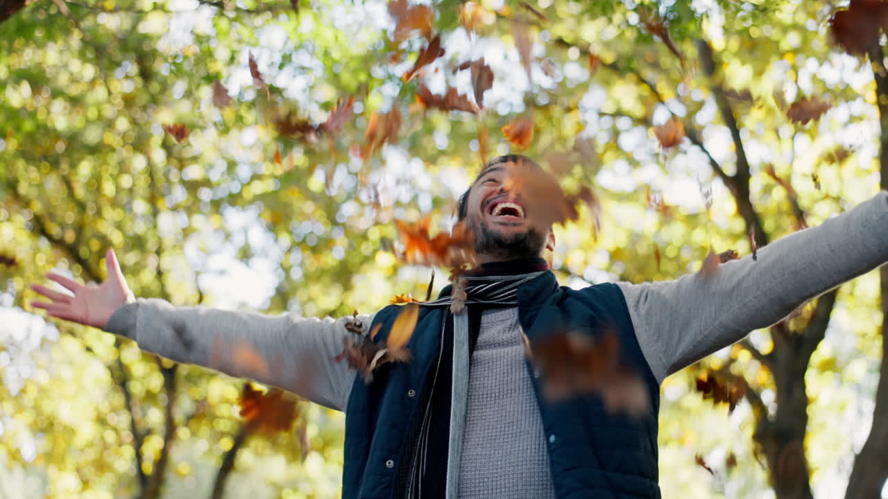 Happy, leaves and a man in nature during autumn