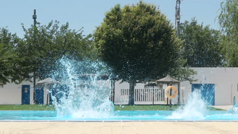 women in swimsuits jumping into a swimming pool