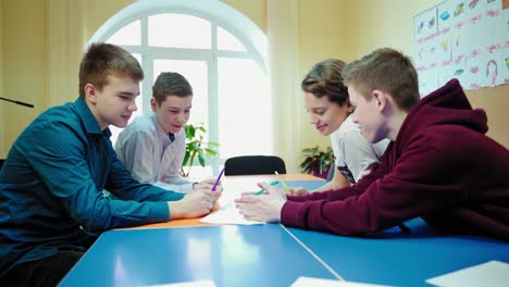 teenage boys work in a group at school. children discussing the same topic together in the classroom. back to school.