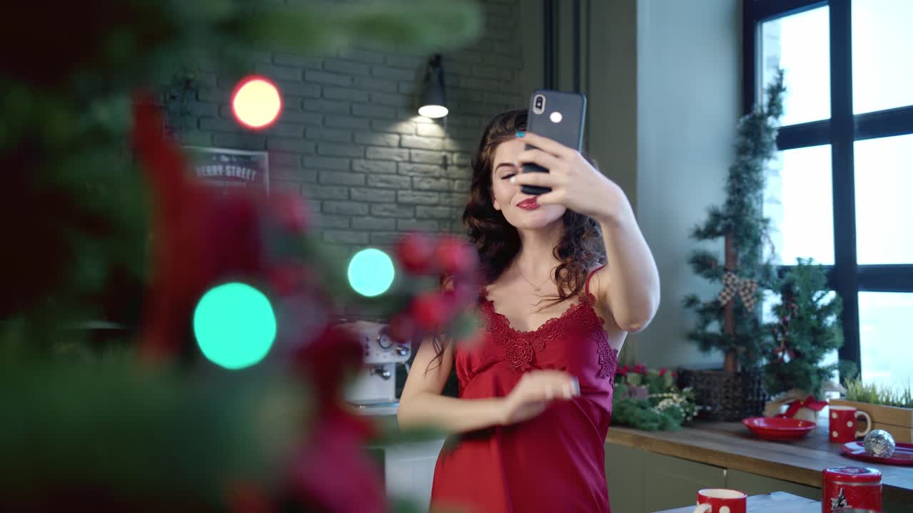 Woman taking a selfie by the Christmas tree in the kitchen