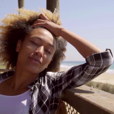 Attractive-young-woman-relaxing-at-a-seafront-cafe