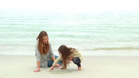 Mutter-Und-Tochter-Zeichnen-Im-Sand