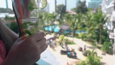 brunette with red nails mixes and drinks frozen mojito